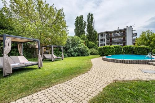 um quintal com uma piscina e um gazebo em Hotel Clariss em Balatonalmádi