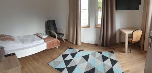 a bedroom with a bed and a table and a rug at Apartamenty Promyk 