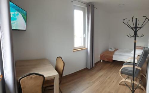 a room with a table and chairs and a bed at Apartamenty Promyk 