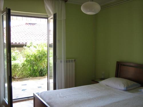 a bedroom with a bed and a sliding glass door at Apartma Janja in Portorož