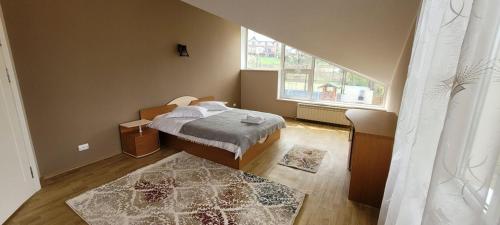 a bedroom with a bed and a large window at BUCIUM CLUB VILA 1 in Iaşi