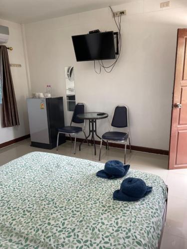 a bedroom with a bed and a table and chairs at Kalae Resort in Ban Nong Ben