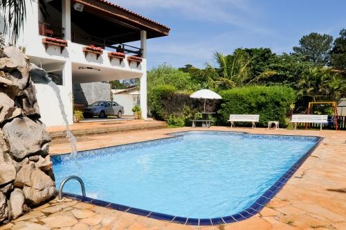 a swimming pool in front of a house at Hotel Nova Odessa in Nova Odessa