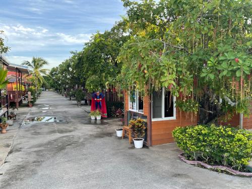 a street next to a house with trees and plants at Kalae Resort in Ban Nong Ben