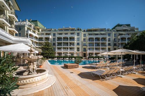 a large hotel with a pool and chairs and umbrellas at Romance Hotel and Family Suites in Saints Constantine and Helena