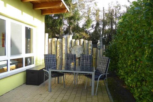 a table and chairs on a patio with a fence at Ferienhaus Gruebsch in Zempin