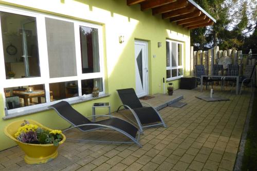 a patio with chairs and a vase of flowers at Ferienhaus Gruebsch in Zempin