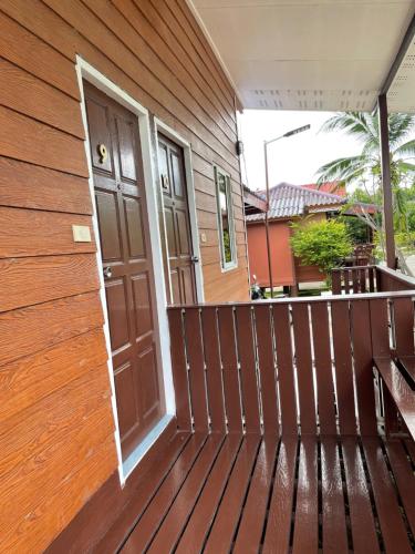 a wooden porch with a door on a house at Kalae Resort in Ban Nong Ben