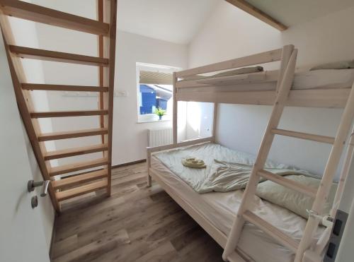 1 dormitorio con literas y escalera en Haus JADEHUUS, en Schweiburg