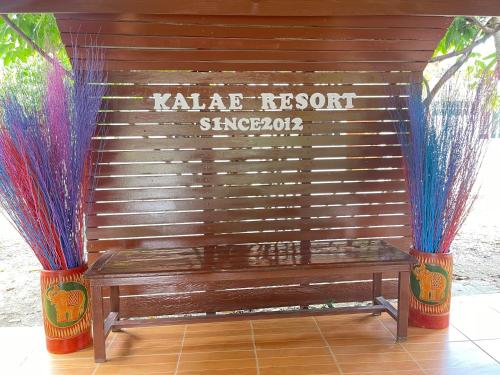 a wooden bench with some colorful puedumes on it at Kalae Resort in Ban Nong Ben