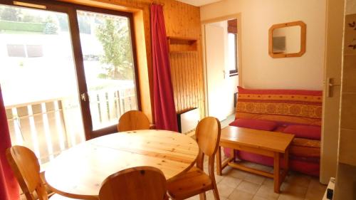 un salon avec une table et un canapé dans l'établissement Appartement typique de montagne, à Thollon-les-Mémises