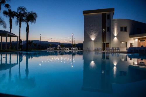 Partenone Resort Hotel في رياس مارينا: مسبح كبير امام مبنى