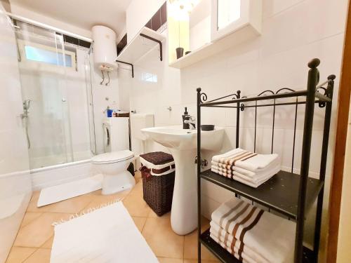 Baño blanco con lavabo y aseo en Apartment Morska oaza, en Klenovica