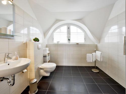 a white bathroom with a sink and a toilet at Villa Fasan in Trent