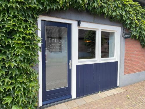 a blue door and window on a building at B&B De Dorpshoeve in Etten