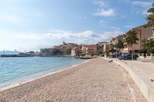 a beach next to the water with buildings at Apartments Sonja in Igrane