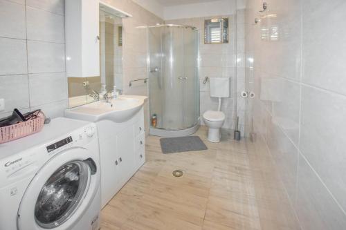 uma casa de banho com uma máquina de lavar roupa e um lavatório em Apartments Toni em Poljana