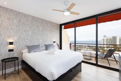 sypialnia z dużym łóżkiem i balkonem w obiekcie 153 SUNNY Olympia By Sunkeyrents w Playa de las Americas