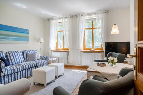 a living room with two couches and a table at Gulfhof Butendiek - Ferienapartments in Neuharlingersiel