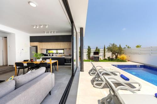 an open living room and kitchen with a swimming pool at Protaras Almaria Villa 16 in Protaras