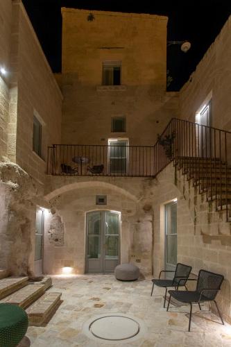 a large stone building with a staircase and chairs at PIANELLE RESORT in Matera