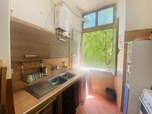 une petite cuisine avec un évier et une fenêtre dans l'établissement ROMA GONDOLA SRLS, à Rome
