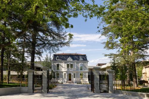 a large white house with a gate at Hôtel Spa Restaurant Villa Castellane in Gréoux-les-Bains
