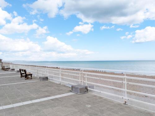 a bench on a pier looking out at the ocean at No Five - Worthing in Worthing