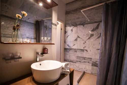 Un baño con lavabo y pared de mármol. en Skotteksgården Cottages, en Ulricehamn