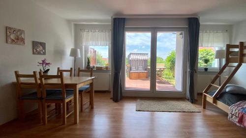 ラーデベルクにあるFerienapartment Casa Heideblick mit Sonnenterrasse & Gartenのダイニングルーム(テーブル、椅子付)、ガラスのスライドドア