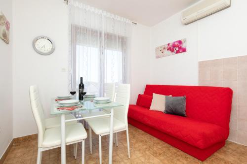 a living room with a red couch and a table at Apartmani Braut in Kornić