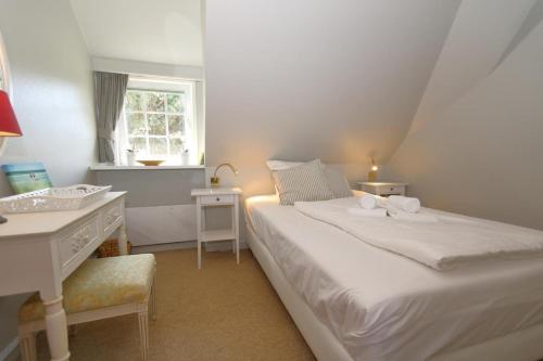 - une chambre avec un lit, un bureau et une fenêtre dans l'établissement Haus-Wattblick-Appartement-M-W-O, à Braderup