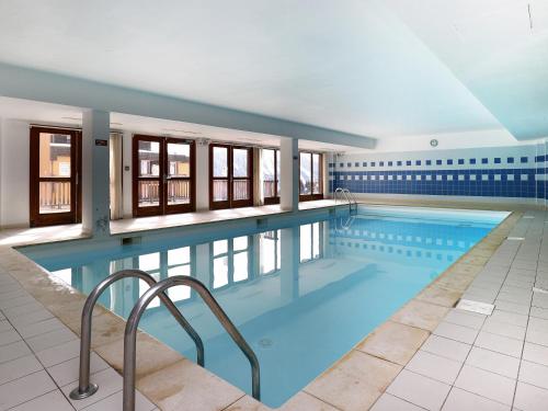 une grande piscine avec de l'eau bleue dans l'établissement B602 - Appartement 3 pieces cabine 8 personnes, à Orcières