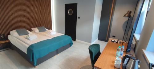a small bedroom with a bed and a table at Kurort Kameralny in Mikołajki
