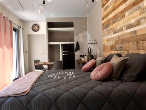 ein Schlafzimmer mit einem großen Bett und einer Holzwand in der Unterkunft La Suite Côté Pool-House Piscine, Sauna & Jacuzzi privatifs in Istres
