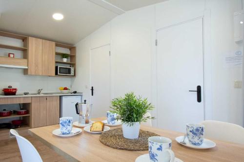 a dining room with a table and a kitchen at Camping Urbion in Abejar