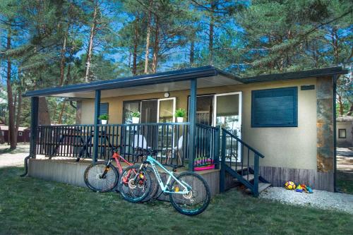 Camping Urbion في أبيجار: منزل به دراجتين متوقفتين أمامه