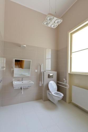a white bathroom with a toilet and a sink at Pensiunea Elphin in Târgu-Mureş