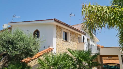 un edificio con palme di fronte di Le Terre di Sicilia a Terrasini