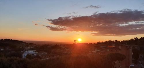 a sunset over a city with the sun setting at A casa di DiGi - Appartment at last floor with panoramic view in Albano Laziale