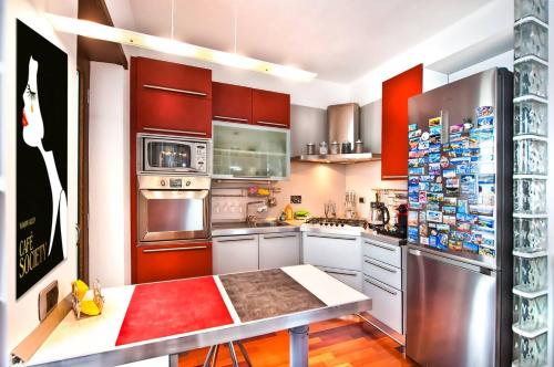 a kitchen with stainless steel appliances and red cabinets at A casa di DiGi - Appartment at last floor with panoramic view in Albano Laziale