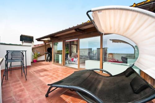 a chair on a patio with a view of the ocean at A casa di DiGi - Appartment at last floor with panoramic view in Albano Laziale