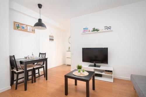 a living room with a tv and a table and chairs at Apartamento BS Oviedo Centro in Oviedo