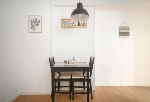 奧維多的住宿－Apartamento BS Oviedo Centro，餐桌,配有两把椅子和一盏灯