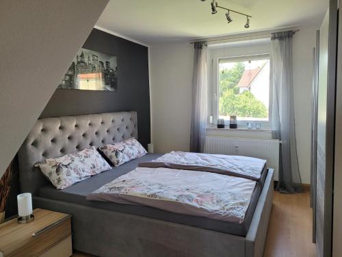 a bedroom with a large bed with a window at Ferienwohnung Melanie Wackersdorf in Wackersdorf