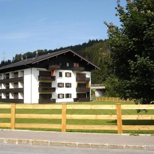 a white building with a wooden fence in front of it at living Appartement in Flachau