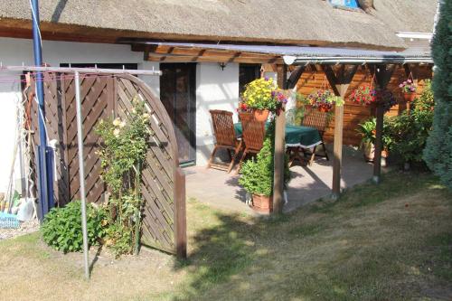 a porch of a house with a table and chairs at Wohnen unter dem Rohrdach in Zempin