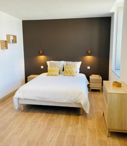 a bedroom with a large white bed with two pillows at LE BON LABOUREUR in Moulins-Engilbert