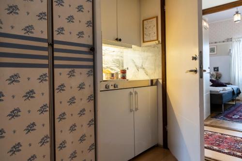una pequeña cocina con nevera y una habitación en Skotteksgården Cottages, en Ulricehamn
