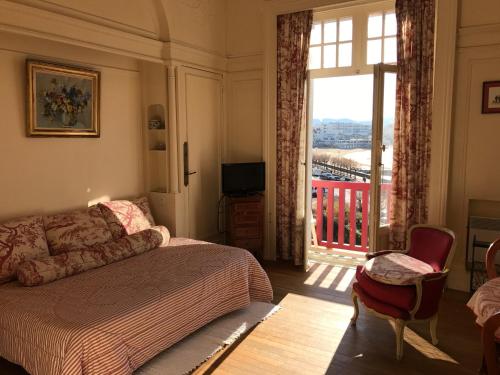 une chambre avec un lit et une grande fenêtre dans l'établissement Résidence Thiers Golf 2 -Charmant studio face à la baie, à Saint-Jean-de-Luz